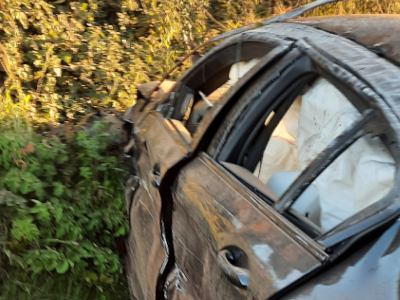 Photo of the side of the crashed BMW, showing the crushed and damaged side and windows.